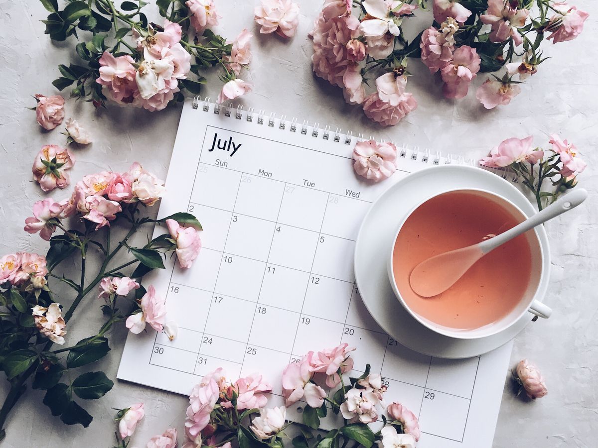 july calendar with pink colored tea and roses arou uewkfrf