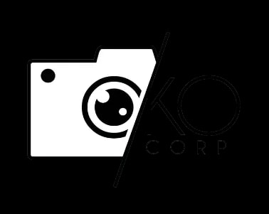 Logo stylisé représentant la moitié d’un appareil photo à gauche et les lettres 'OKO Corp' à droite, séparés par une ligne diagonale.