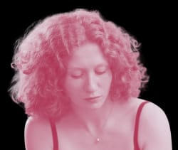 Portrait d'une femme aux cheveux longs et bouclés, au regard sérieux, teintée d'une nuance rosée, avec un fond transparent.