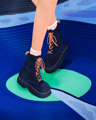 Bottes noires avec des lacets orange sur un fond coloré représentant une surface aquatique.