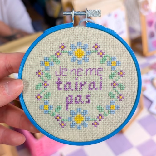 Porte clé vert à motif soleil sur fond dégradé rose, violet et jaune pastel