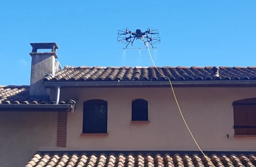 Drone en train de démousser une toiture