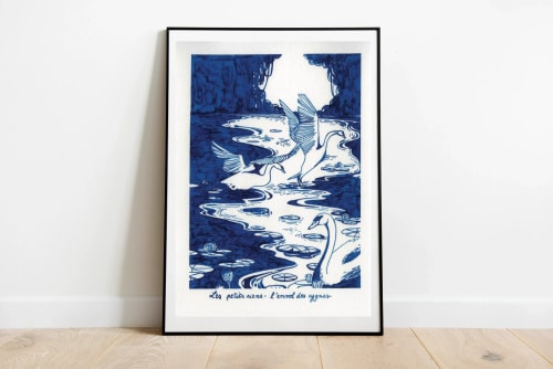 Illustration encadrée en bleu et blanc représentant un paysage marin abstrait, avec vagues, rochers et oiseaux, posée contre un mur blanc.