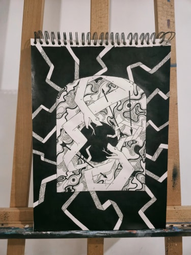 Dessin abstrait en noir et blanc à l'encre posé sur un chevalet, représentant deux serpents s'affrontant autour d'une porte entourée de motifs ondulés et géométriques.