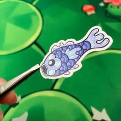Illustration de créatures marines bleues, dont une pieuvre tachetée, un poisson et un hippocampe, sur une feuille blanche posée sur un fond vert.