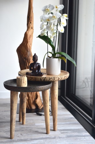 fleurs et statue zen sur table en bois