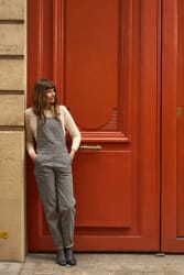 Christine Mercadier portant la salopette rayée de la marque devant une porte cochère parisienne