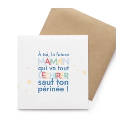 Carte de vœux blanche avec une enveloppe kraft, portant l'inscription humoristique : À toi, la future maman qui va tout déchirer sauf ton périnée ! Décorée de petites étoiles dorées.