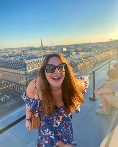Portrait photo de Joleen Emory riant sur les toits de Paris.