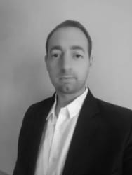 Portrait photo en noir et blanc de Pascal Jouannel souriant à la caméra.