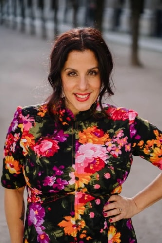 Portrait photo de Frances Vieras Blanc, CEO d'Eat the Cake et experte designer. Elle porte une robe à fleur et sourit à la caméra