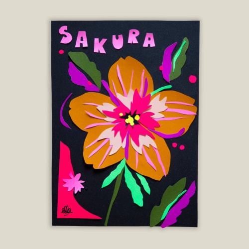 Collage de papier sur fond noir représentant une fleur stylisée dans les tons ocre et rose, avec le mot SAKURA écrit en lettres roses découpées en haut.