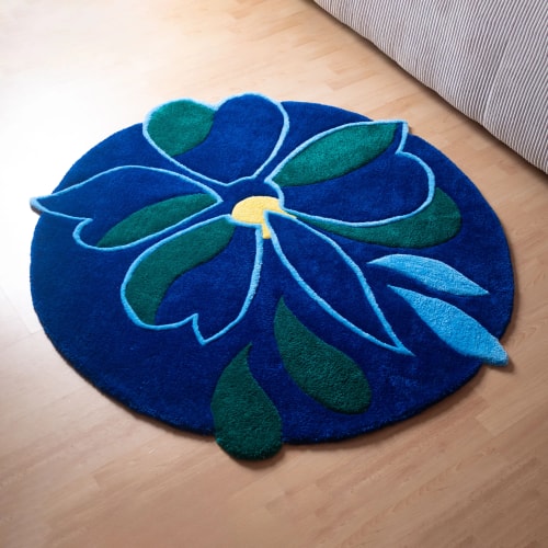 Une peinture aux couleurs vives représentant des fleurs tropicales roses, rouges et orange contrastant avec un feuillage vert sur un fond noir.