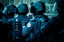 Des membres du GIGN, portant des casques et se tenant en enfilade, avec des équipements de protection