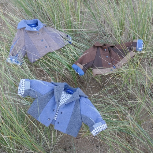 Veste pour enfant doublée en tissu bleu à carreaux, avec extérieur marron, manches retroussées et boutons-pression.