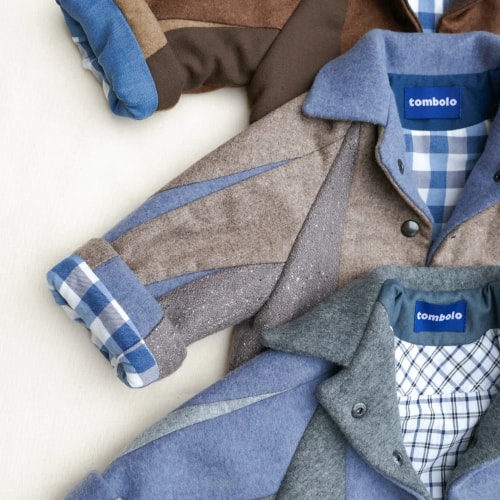 Veste légère marron en simili cuir, à col chemise, boutonnée sur le devant, avec deux grandes poches plaquées et manches longues.