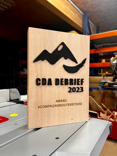 Trophée durable en bois massif sur mesure fabriqué en Savoie. Récompense podium personnalisable, responsable et made in France.