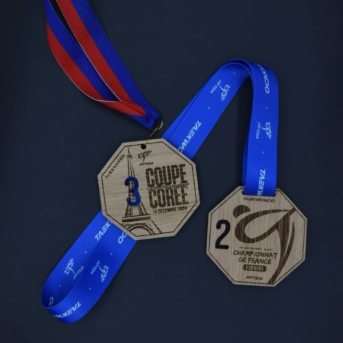 Médaille haut de gamme en chêne massif en bois personnalisable fabriquée en Savoie. Récompense finisher en bois sur mesure pour événement sportif.