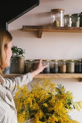 Fanny Taudou de Taudou List rangeant des condiments et épices dans des bocaux en verre dans une cuisine lumineuse