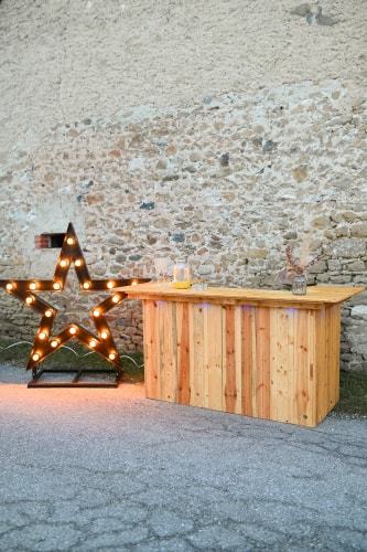 Un bar en bois et une grande étoile lumineuse près d'un mur en pierre.