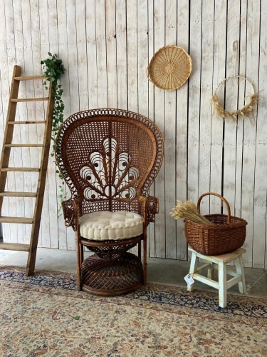Un bar moderne avec un comptoir sombre, des murs en béton et un éclairage doux. Au centre, une table ronde en bois avec un seau à glace contenant une bouteille et deux verres de vin. À l'arrière-plan, une sélection de boissons est affichée sur un mur.