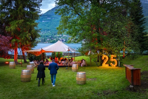 Un soudeur portant un casque de protection et des gants, concentré sur son travail, crée des étincelles et de la fumée en soudant une pièce métallique sur une table d'atelier.