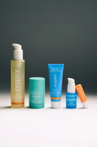 Cinq produits de soins de la peau de la marque Respire, y compris un nettoyant, un masque, une crème hydratante et un sérum, disposés en ordre sur une surface claire.