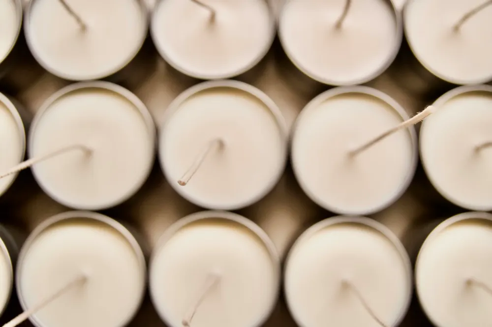 Pouring melted wax into a candle container