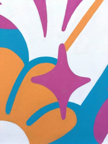 Détail d'une peinture murale colorée avec des formes organiques orange et bleu, agrémentées d'une étoile rose à quatre branches stylisée sur un fond blanc.