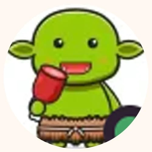 Petit personnage de dessin animé vert de style gobelin, souriant, tenant une massue rouge et portant un pagne en paille.