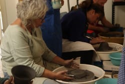 Participants réunis autour d’un atelier de céramique