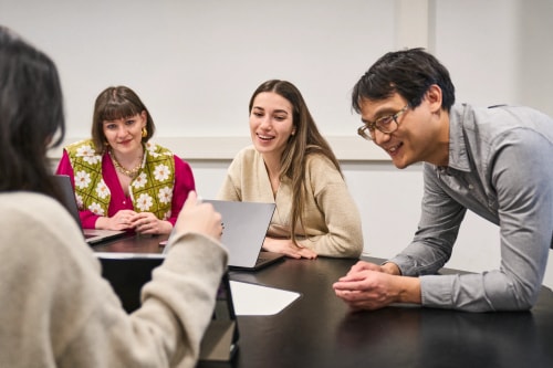 L'équipe de l'Agence Vitrine assise autour d'une table, présentant une recommandation stratégique en communication.
