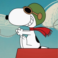 Snoopy, le chien blanc à taches noires, assis sur une niche rouge, portant un casque d'aviateur vert, des lunettes et une écharpe rouge, avec un grand sourire.