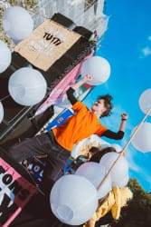 artiviste incarnant la joie militante lors d'une manifestation pour plus de justice sociale et climatique